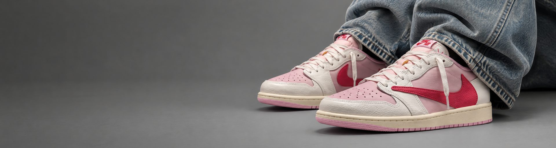 Travis Scott x Air Jordan 1 Low Sail Tropical Pink puestas, con vaqueros anchos